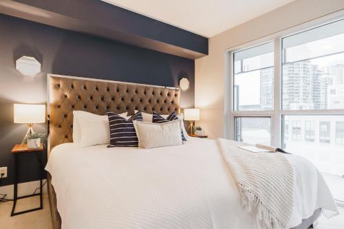 um quarto com uma cama grande e uma janela grande em Jarvis Inn em Toronto