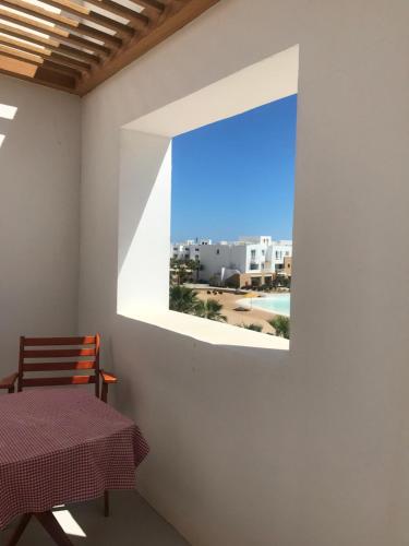 a room with a table and a window with a view at El Gouna Swan Lake I Direct Lake View I 3 Master Bedrooms Chalet in Hurghada