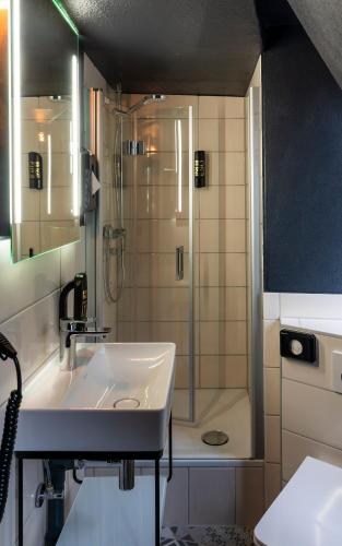 a bathroom with a sink and a shower at Trip Inn Hotel Sachsenhausen in Frankfurt/Main