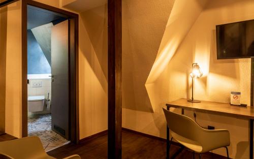 a room with a desk and chairs and a mirror at Trip Inn Hotel Sachsenhausen in Frankfurt