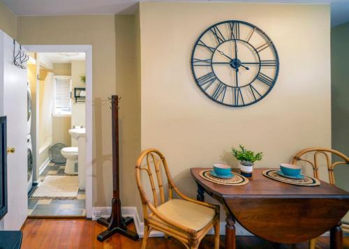 una sala da pranzo con tavolo e orologio sul muro di Sunny 4 Bed 2 Bath Providence a Providence