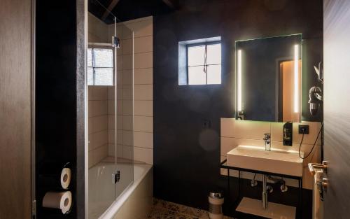 a bathroom with a sink and a mirror and a tub at Trip Inn Hotel Sachsenhausen in Frankfurt/Main