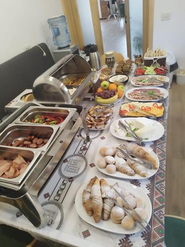 a buffet table with many plates of food on it at Blumenhof Bucovina in Voronet