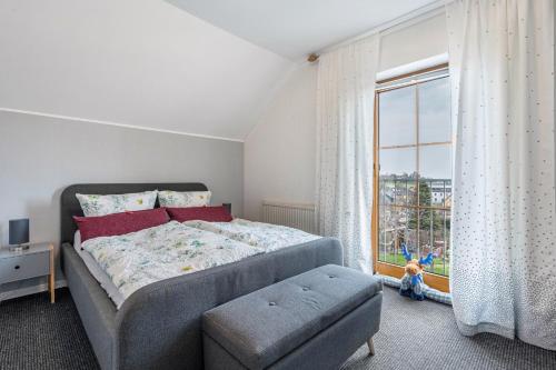 een slaapkamer met een bed en een groot raam bij Fewo Omatina in Bannewitz