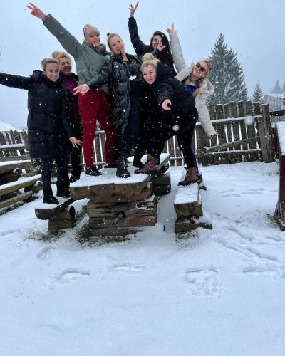 a group of people jumping in the snow at Blumenhof Bucovina in Voronet