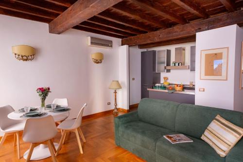 a living room with a green couch and a table at Pantheon Luxury House - ZEN 28 in Rome
