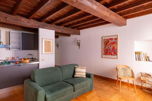a living room with a green couch and a kitchen at Pantheon Luxury House - ZEN 28 in Rome