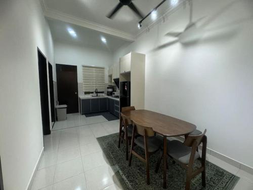 a kitchen with a wooden table and chairs in a room at Hazzani Homestay KLIA in Banting