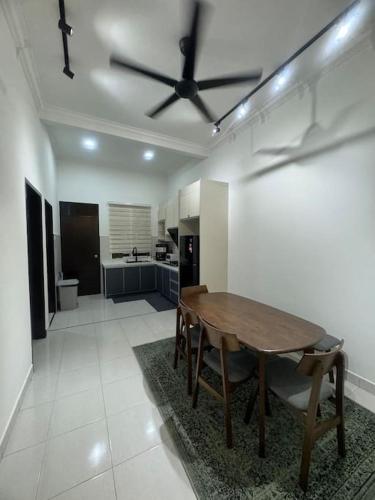 a living room with a table and a kitchen at Hazzani Homestay KLIA in Banting