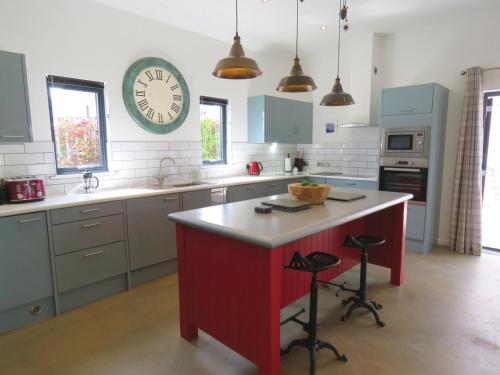 una cocina con un reloj grande en la pared en Umber Cottage, en Bradworthy