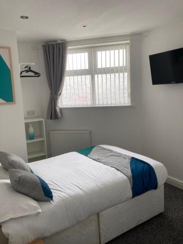 a bedroom with a large bed and a window at Palatine Aparthotel in Liverpool