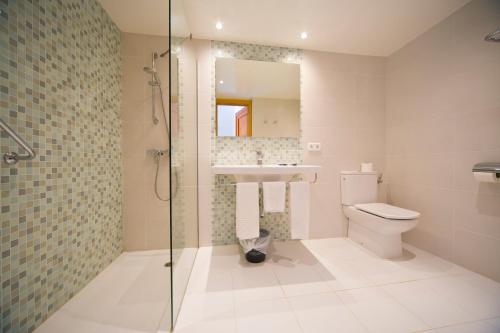 a bathroom with a toilet and a sink and a shower at Hotel Calimera Fido Gardens in Cala d´Or