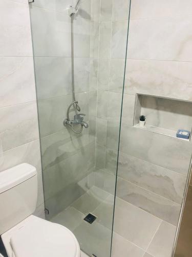 a shower with a glass door next to a toilet at Apartamento centro de la ciudad 2 in San Pedro de Macorís