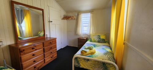 a bedroom with a bed and a dresser and a mirror at Meyenburg Unit 1 in Mount Morgan