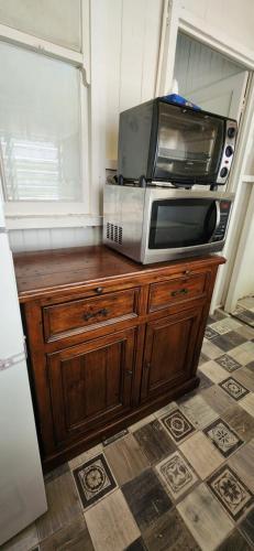 a microwave sitting on top of a wooden cabinet at Meyenburg Unit 1 in Mount Morgan