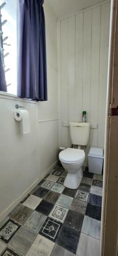 a small bathroom with a toilet and a window at Meyenburg Unit 1 in Mount Morgan