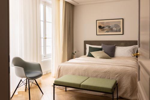ein Schlafzimmer mit einem Bett, einem Stuhl und einem Fenster in der Unterkunft The Hamlet in Genf