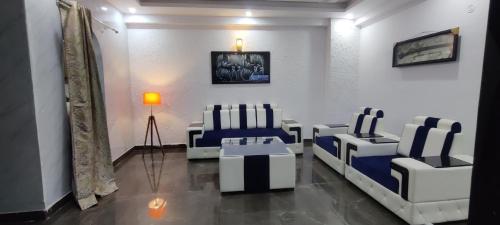 un salon avec des chaises bleues et blanches et une lampe dans l'établissement 360 degree mountain view penthouse, à Rishikesh
