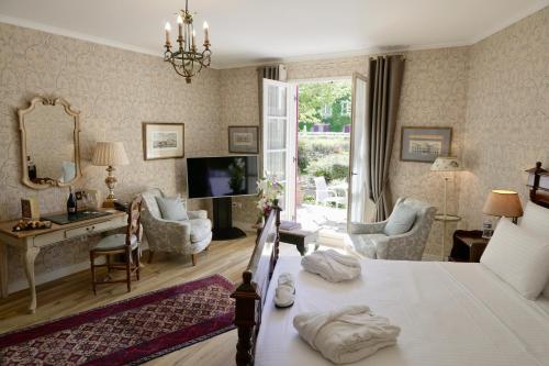 um quarto com uma cama e uma sala de estar em Le Manoir de Gressy em Gressy