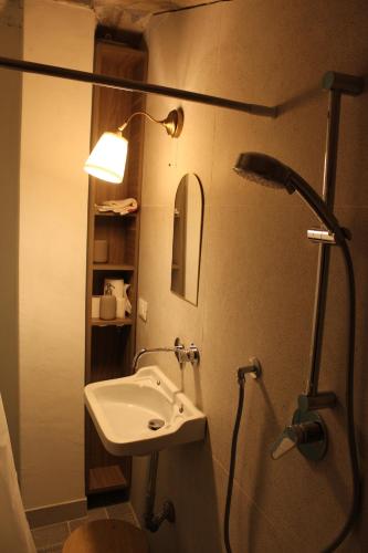 a bathroom with a sink and a mirror and a lamp at La Casa nell'Orto in Fermo