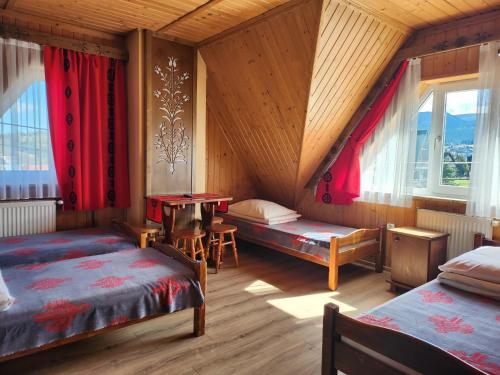 a bedroom with two beds and a table in it at Willa u Renaty - Widok na Giewont in Zakopane