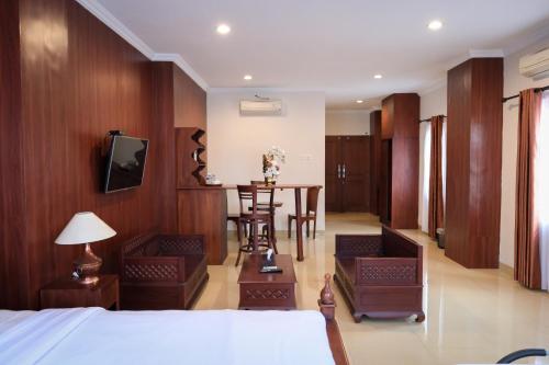 a bedroom with a bed and a table and chairs at The Garden Suites New in Solo