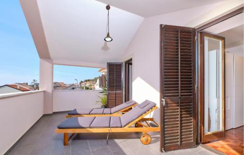 a room with a balcony with a bed and a window at 3 Bedroom Nice Apartment In Mali Losinj in Mali Lošinj