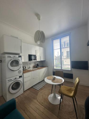Il comprend une cuisine avec une table et un lave-linge. dans l'établissement La Nacre - Logement de charme - Cabourg, à Cabourg