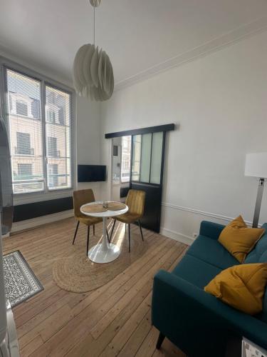 un salon avec un canapé et une table dans l'établissement La Nacre - Logement de charme - Cabourg, à Cabourg
