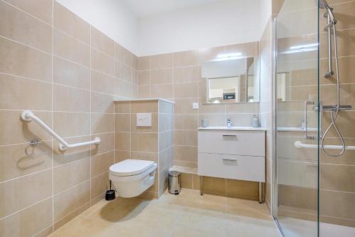 une salle de bain avec toilettes et douche en verre dans l'établissement OVELIA Fréjus - La Villa Marina, à Fréjus