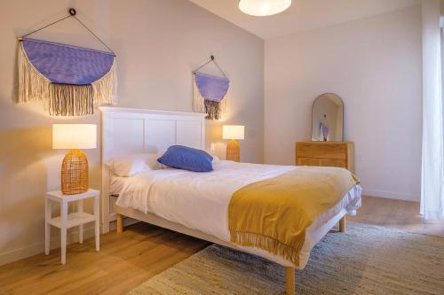 - une chambre avec un lit, deux lampes et un miroir dans l'établissement OVELIA Fréjus - La Villa Marina, à Fréjus