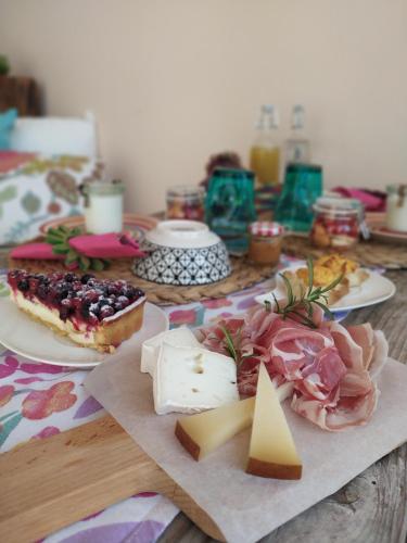 una mesa cubierta con platos de comida y queso en Il Sentiero B&Bìo, en SantʼAntìoco