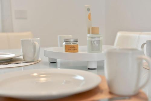 una mesa con un plato blanco y tazas en ella en Appartamento Medea, en Cavernago