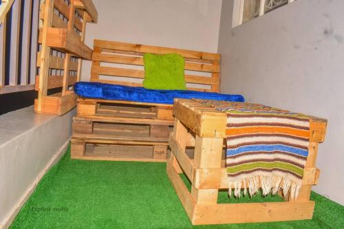 een slaapkamer met een houten bed en groen tapijt bij The Bay House in Homa Bay