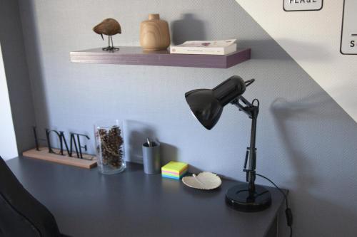 a desk with a lamp and other items on it at Atlantis - Studio - parking - lumineux in Vannes