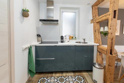 - une cuisine avec une armoire bleue et un évier dans l'établissement Le St-Jean, à Colmar