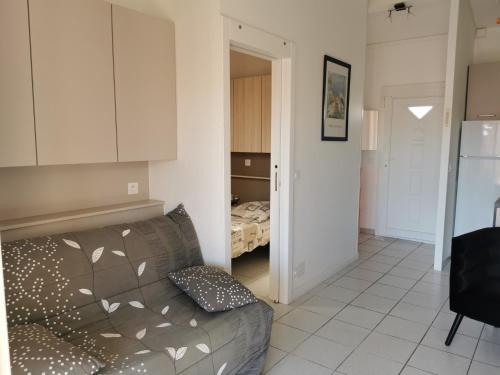 a living room with a couch and a bedroom at Rue de Corfou Les Grenadines in Sainte-Marie-la-Mer
