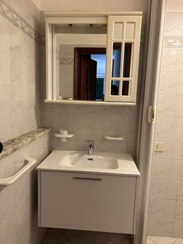 Baño blanco con lavabo y espejo en Ca' da Nuccia, en Riomaggiore