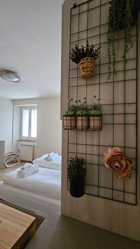 una camera con un letto e piante in vaso su un muro di Piccolo Loft a Foligno