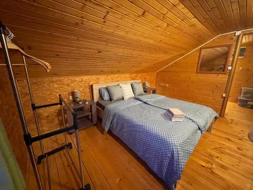 a bedroom with a bed in a wooden cabin at NuA House "Kapri" in Gornji Štoj