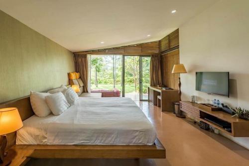 1 dormitorio con 1 cama grande y TV en Villa R331 Forest Flamingo Dai Lai Resort, en Phúc Yên