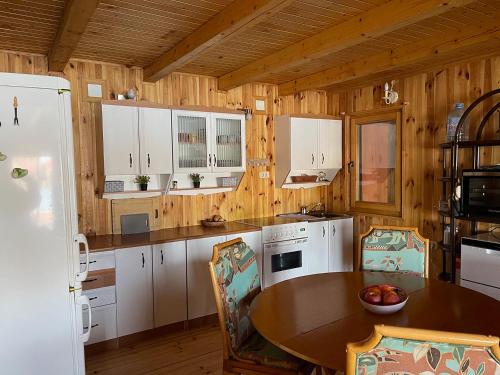 cocina con armarios blancos y pared de madera en NuA House "Kapri", en Gornji Štoj