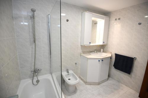 y baño con ducha, aseo y lavamanos. en Coqueto apartamento en Raxó, Sanxenxo, en Raxó