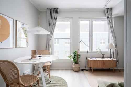 een woonkamer met een witte tafel en stoelen bij Kaunis ja toimiva uusi yksiö in Kuopio