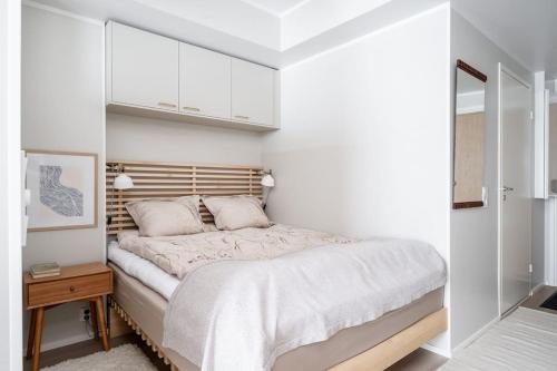 um quarto com uma cama grande e uma cabeceira em madeira em Kaunis ja toimiva uusi yksiö em Kuopio