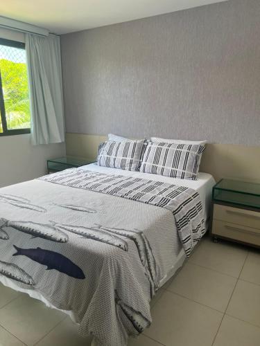 a bedroom with a large bed with white sheets and pillows at Carneiros Beach Resort - Flat 205-A in Praia dos Carneiros