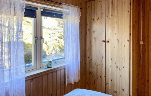 a bedroom with a window with white curtains and a bed at 1 Bedroom Stunning Apartment In Hauge I Dalane in Sogndalsstrand