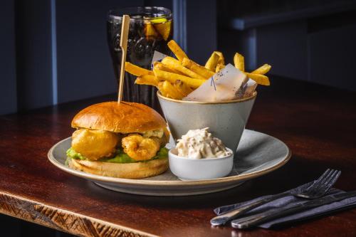 a plate with a sandwich and fries and a bowl of dips at The Pied Bull in Chester