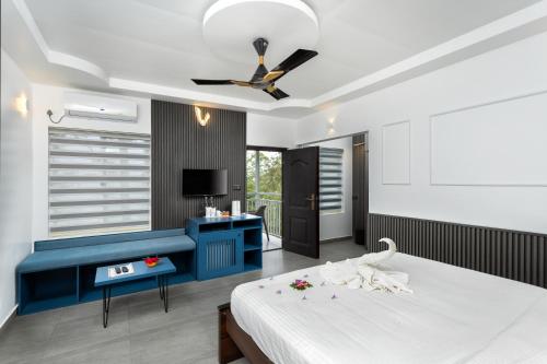 a bedroom with a blue and white bed and a television at Eterno Camellia & Elettaria Resort with Pool in Munnar