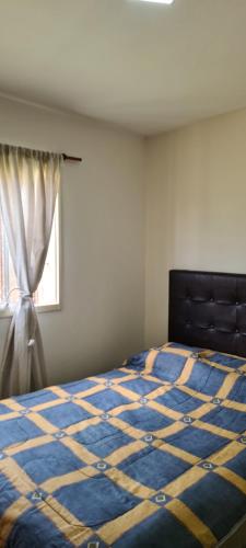 Schlafzimmer mit einem blauen und gelben Bett und einem Fenster in der Unterkunft Cómoda Casa en ciudad de la Punta; San Luis in La Punta